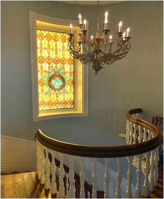 Sunlight streams through the stained glass window of this historic home